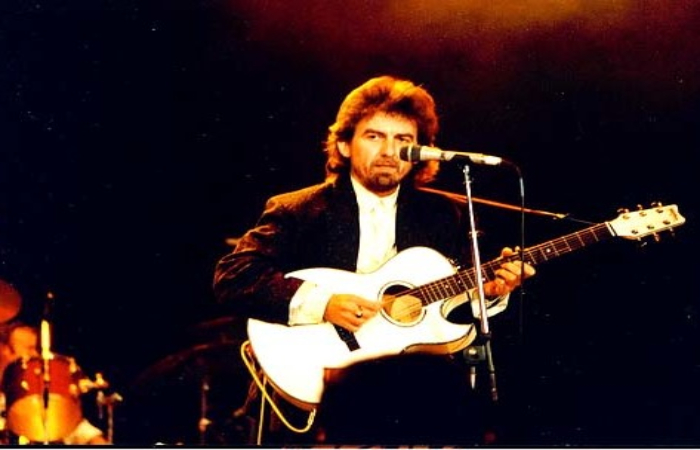 Picture showing George Harrison playing guitar.