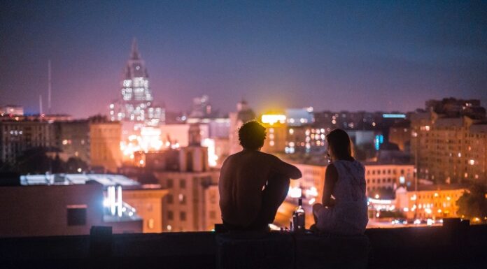 Couple looking into city Photo by Alexander Popov on Unsplash