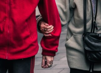 Elderly couple holding hands