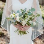 Woman in white wedding dress holding flower bouquet