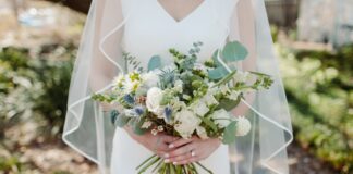 Woman in white wedding dress holding flower bouquet