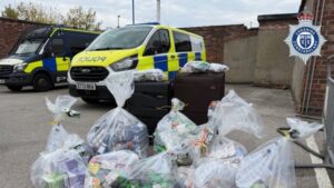 Police vans with bags of the seized goods.