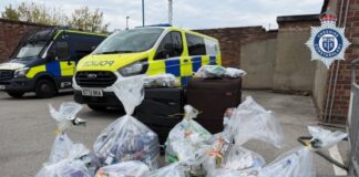 Police vans with bags of the seized goods.