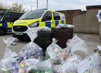 Police vans with bags of the seized goods.