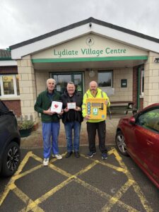 Mark King delivering defibrillator to Lydiate Village Centre
