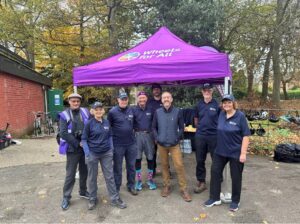 A photo of Chris Boardman CBE with the team of staff and volunteers at Wheels for All Birkenhead Park.