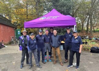 A photo of Chris Boardman CBE with the team of staff and volunteers at Wheels for All Birkenhead Park.