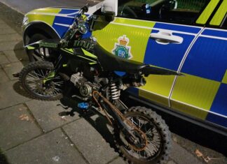 Scrambler bike leaning up against a police car