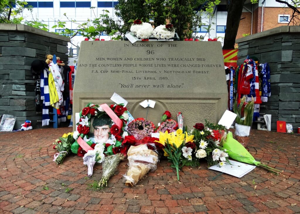 An image of the Hillsborough memorial at Hillsborough Stadium, surrounded by flowers laid in remembrance.