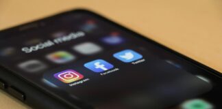 Black Iphone showing several social media apps, including instagram, facebook and X