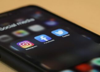 Black Iphone showing several social media apps, including instagram, facebook and X