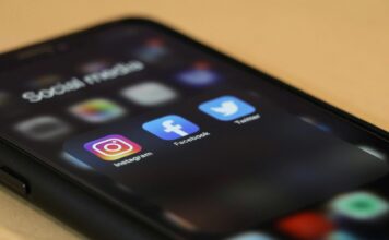 Black Iphone showing several social media apps, including instagram, facebook and X