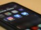 Black Iphone showing several social media apps, including instagram, facebook and X