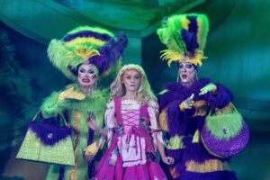 A picture of Katie McGlynn alongside the ugly step sisters on stage.