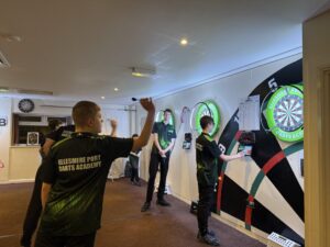 Image shows Ellesmere Port Darts Academy, players throwing darts at board