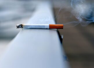 A photo of a cigarette resting on a wall