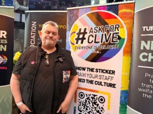 Co-founder of Ask for Clive campaign Clive Duffey standing in front of an Ask for Clive sign.