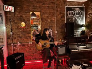 Musician Niamh McNally performing with a guitar at Rockpoint Records