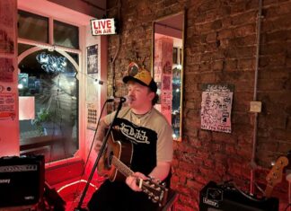 Musician Paddy Turner performing with a guitar at Rockpoint Records