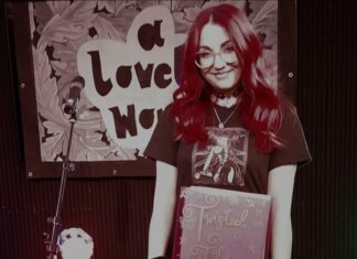Photo of Hayley Lynn Gordon the poet holding a folder of her poetry