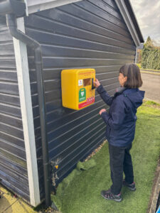Woman accessing defibrillator.