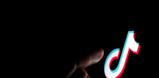 Stone / UK - July 28 2019: TikTok app logo on the screen and a finger about to touch it. - adobe stock image